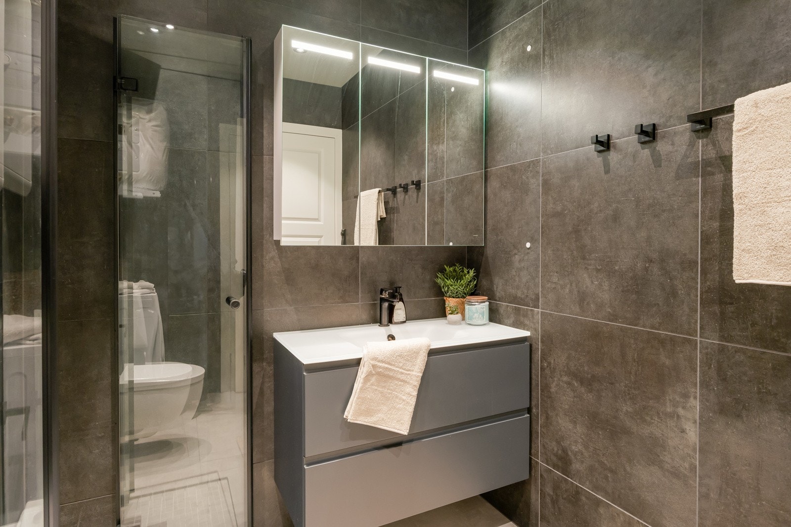 Lekkert moderne bad med flislagte overflater, gulvvarme og downlights i tak. Tilstandsgrad 1 fra takstmann. Galleribilde