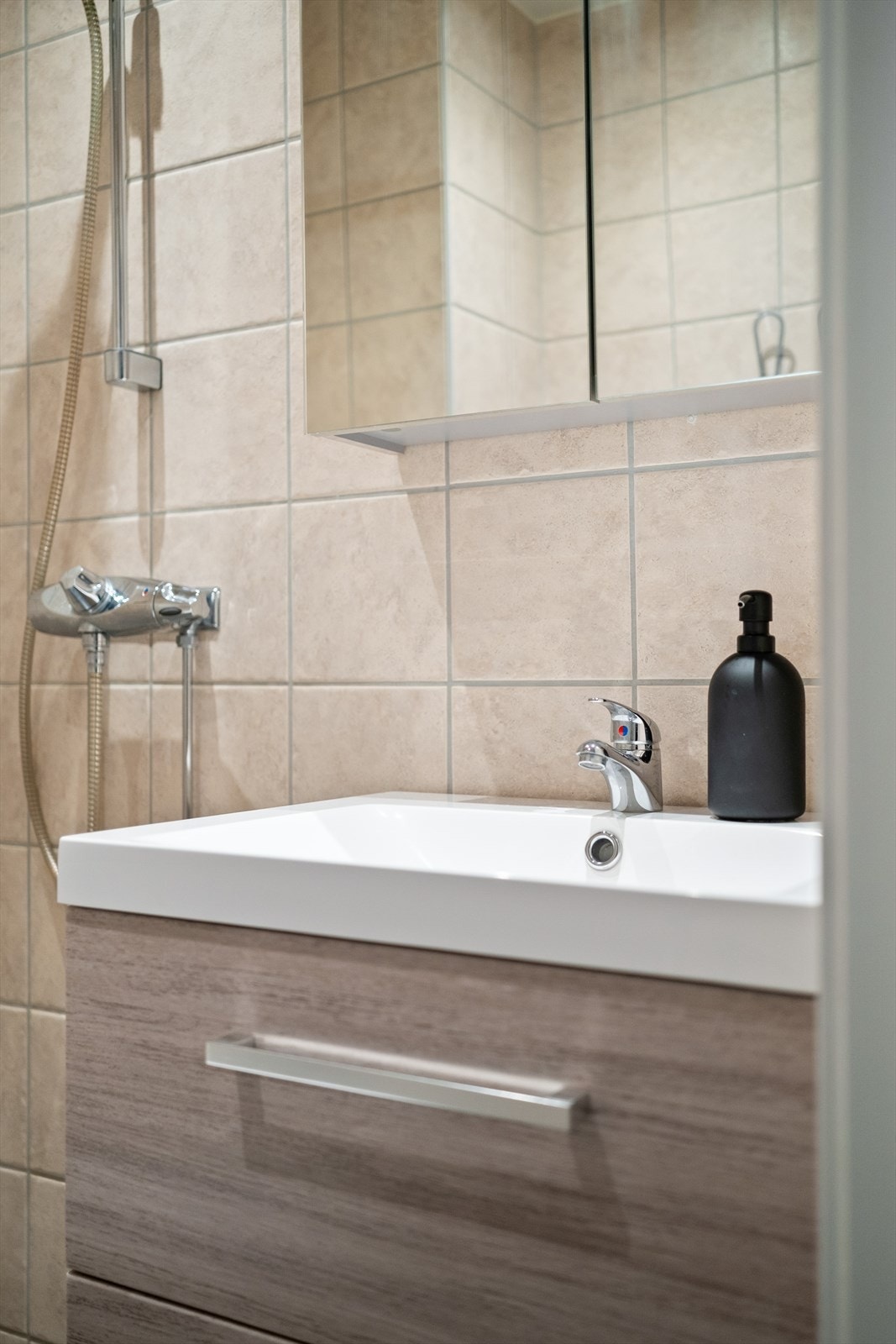 Innredet med vegghengt klosett, servant nedfelt i innredning, speil og dusjhjørne med forheng. Naturlig ventilering. Galleribilde