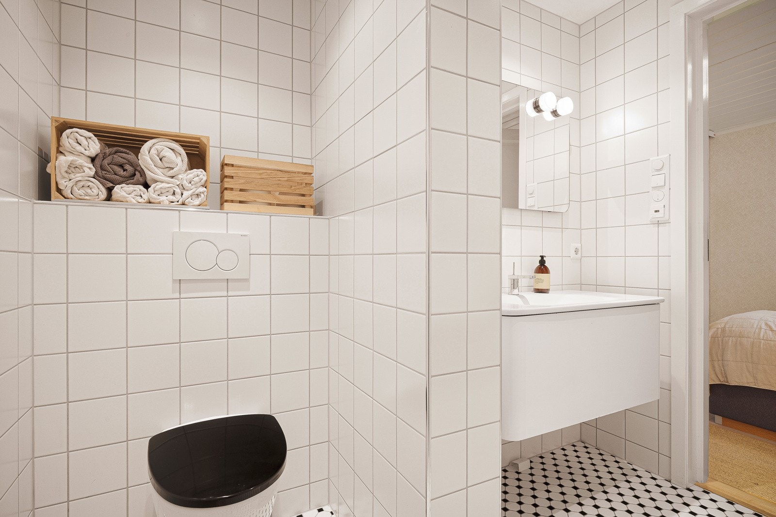 Badet består av vegghengt toalett, dusjhjørne med glassdører, elektrisk håndklevarmer og servant med oppbevaring. I tillegg speil med belysning. Galleribilde