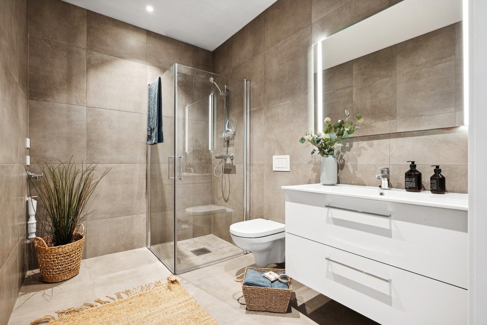 Badet leveres med moderne innredning, vegghengt toalett og opplegg for vaskemaskin. Galleribilde