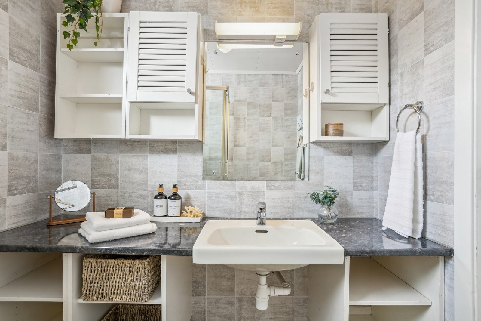 Romslig innredning med benkeplate og servant. Speil og belysning over. Galleribilde