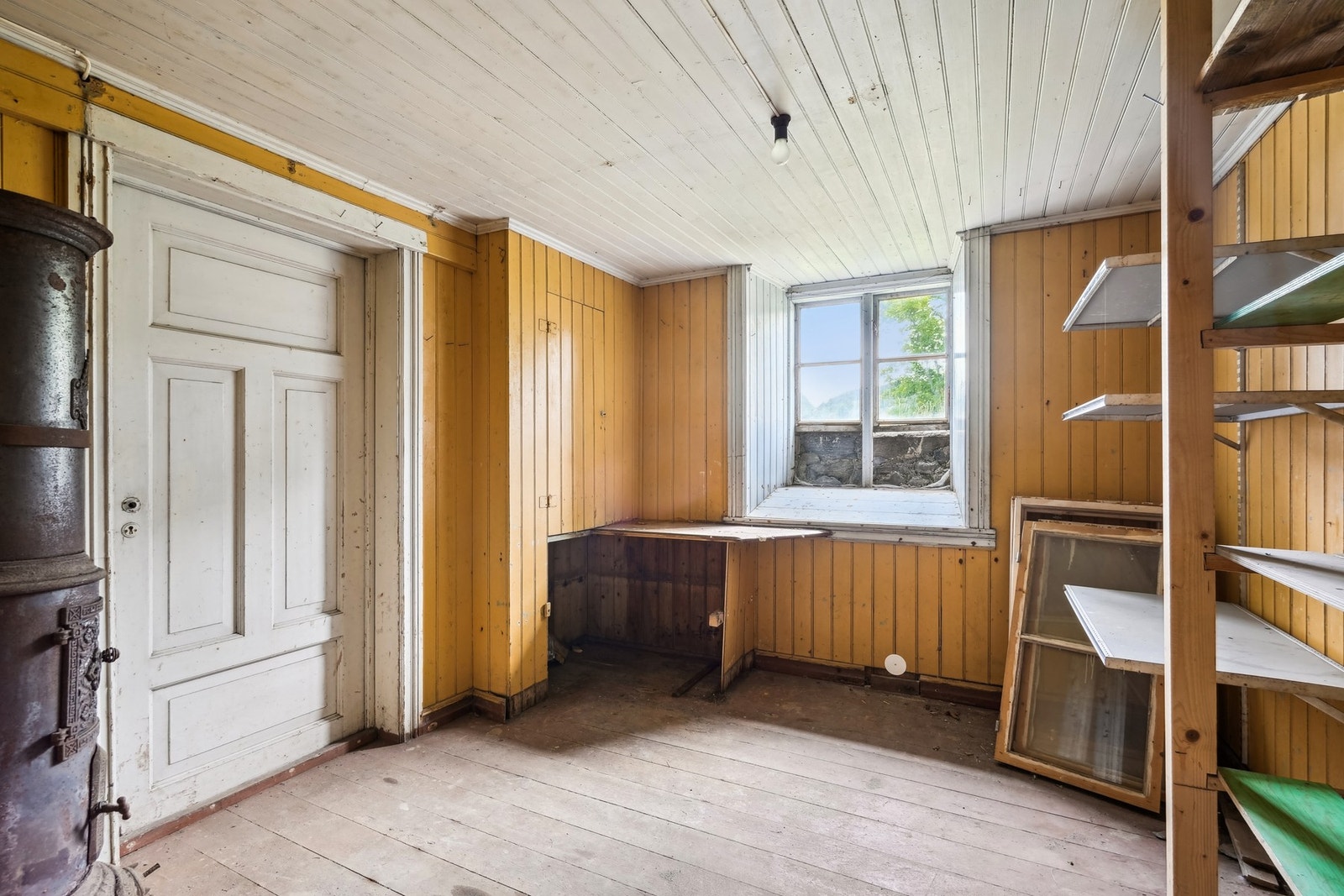 Bod med plass til oppbevaring og en flott eldre vedovn. Galleribilde