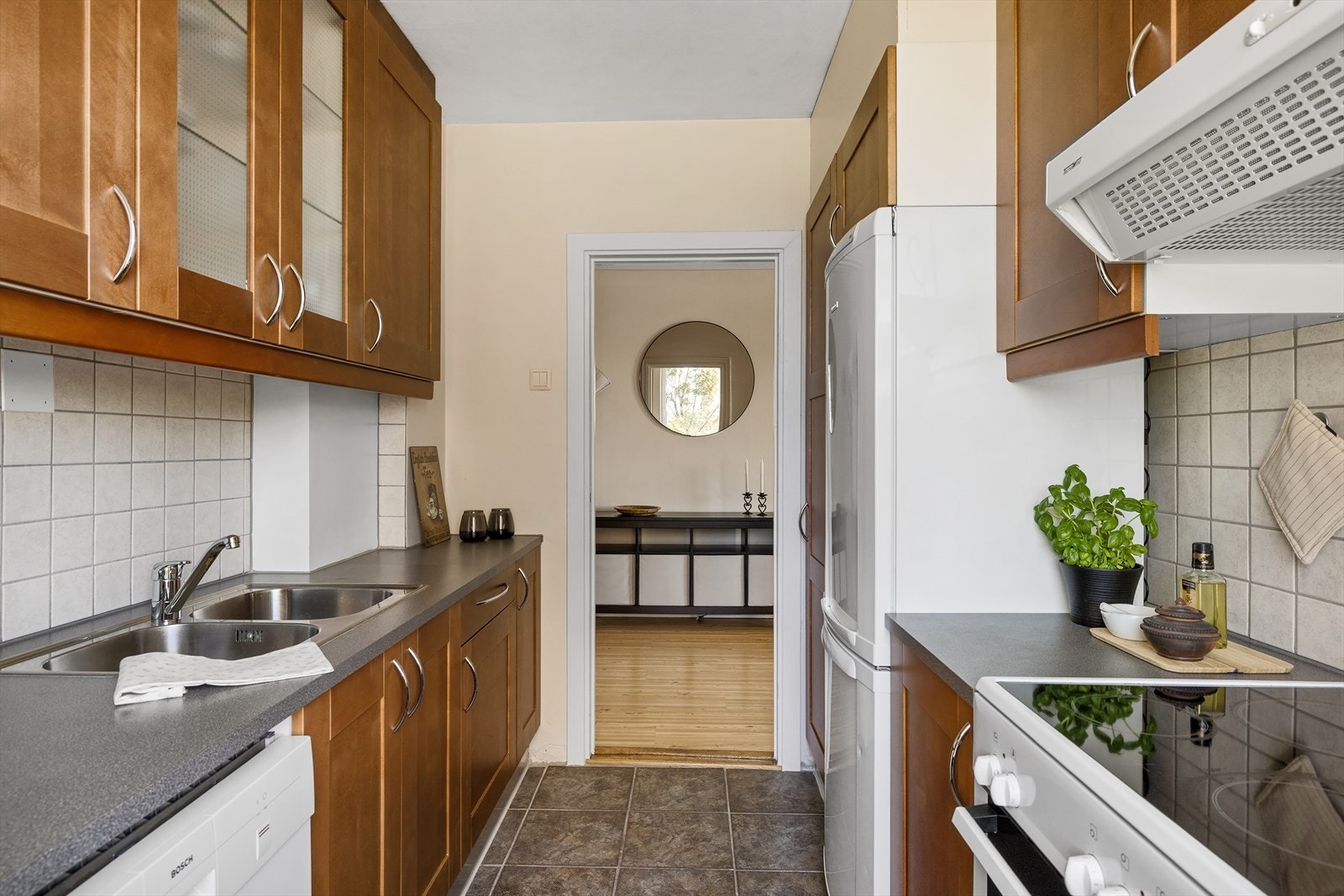 Integrerte hvitevarer inkluderer en frittstående komfyr og en halvintegrert oppvaskmaskin fra Bosch, samt et kjøl-/fryseskap fra Electrolux. Galleribilde