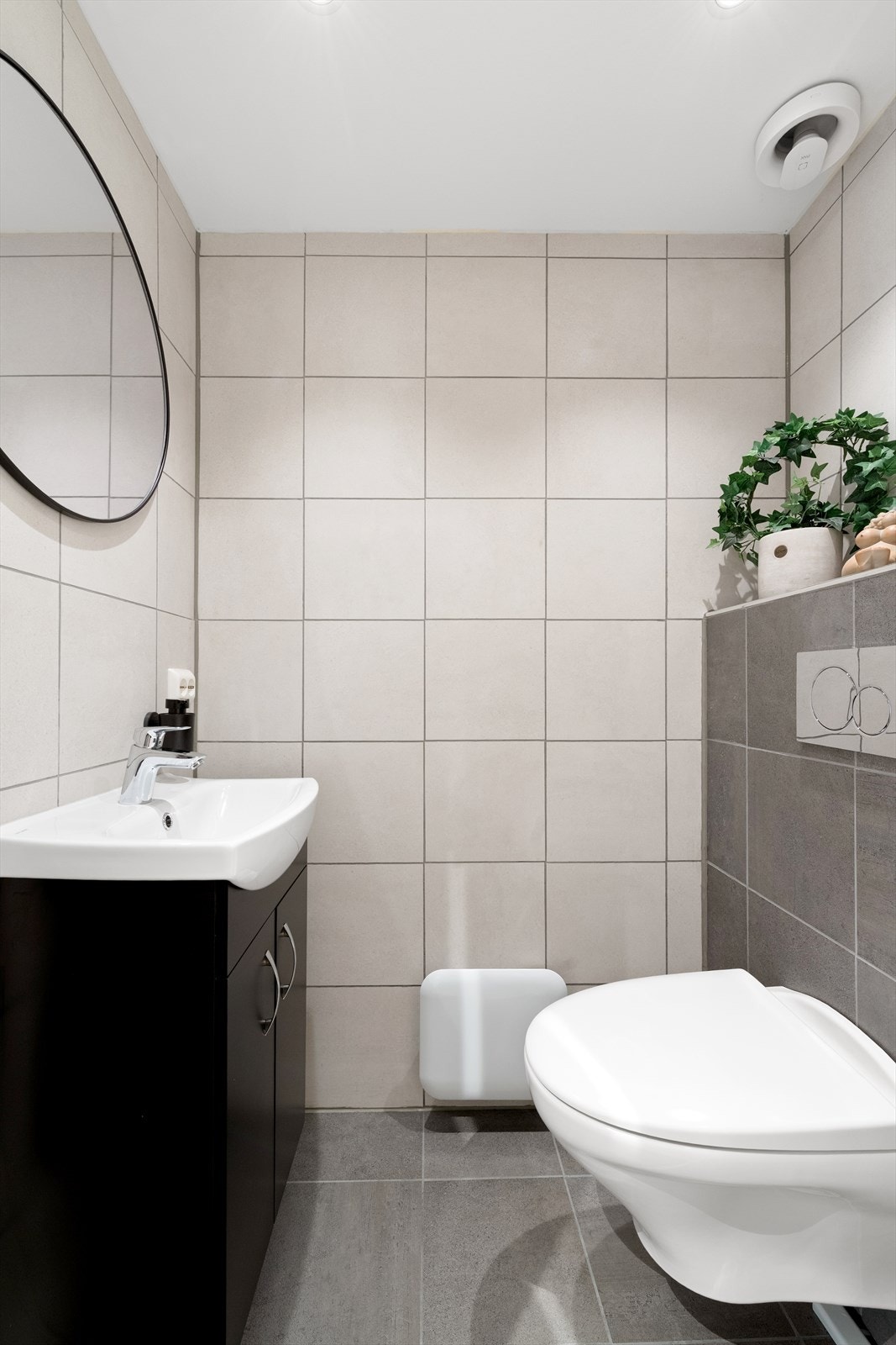 Delikat toalettrom med vegghengt toalett, moderne baderomsinnredning med nedfelt vask. Galleribilde