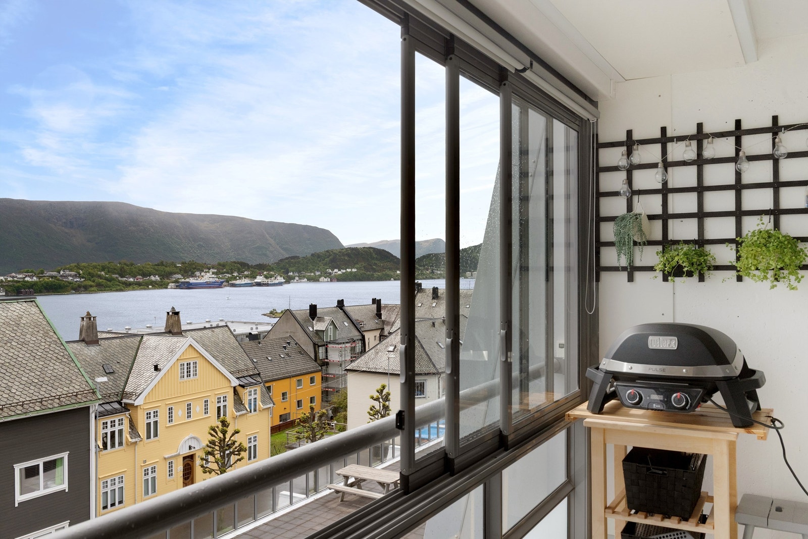 Flott utsikt mot fjord og fjell fra den innglassede balkongen Galleribilde