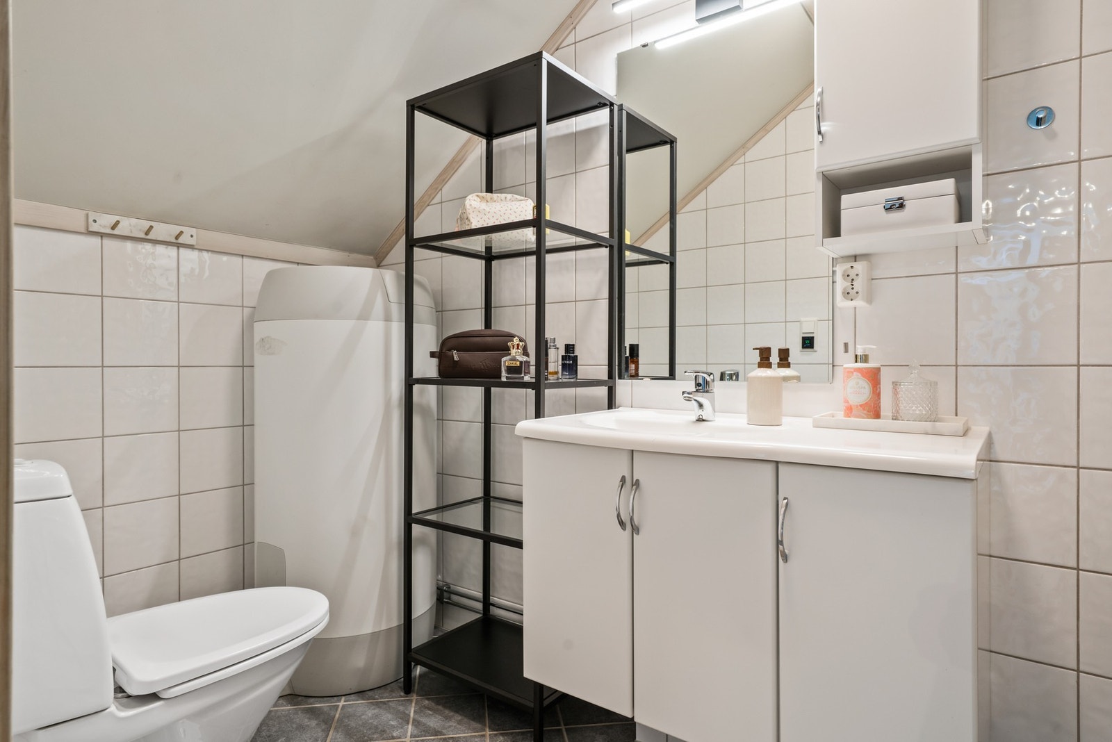 Badet har baderomsinnredning, dusjkabinett og gulvklosett. Galleribilde