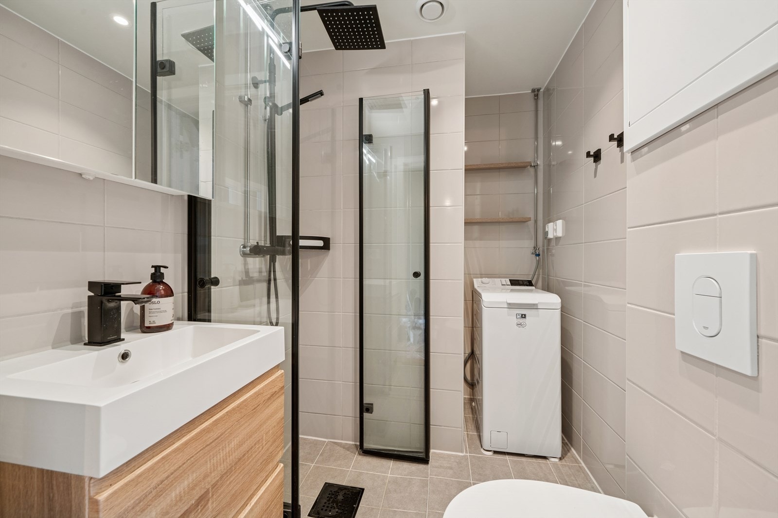 Badet ble pusset opp i 2022 og har flislagte gulv og vegger, vegghengt toalett med innebygd sisterne, samt dusjhjørne med regnfallsdusj og svarte profiler. Galleribilde