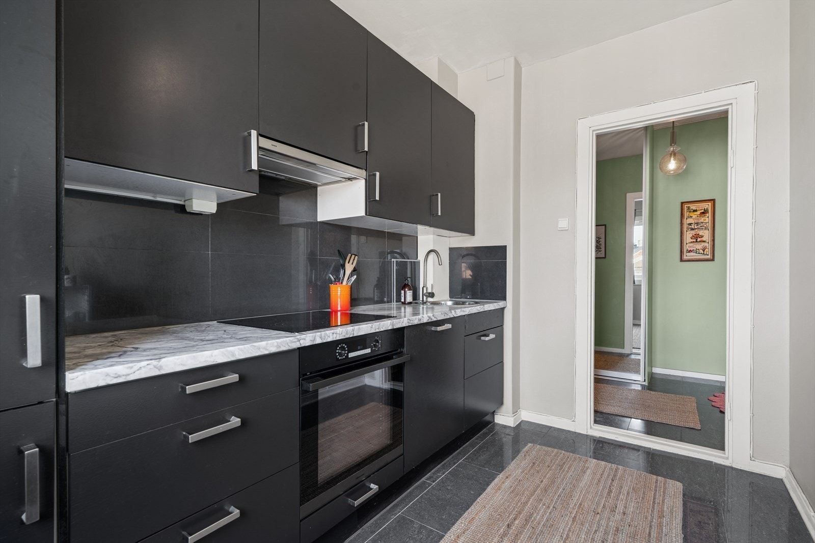 Praktisk og funksjonell løsning med integrerte hvitevarer og flislagt gulv - perfekt for både hverdag og gjester. Galleribilde