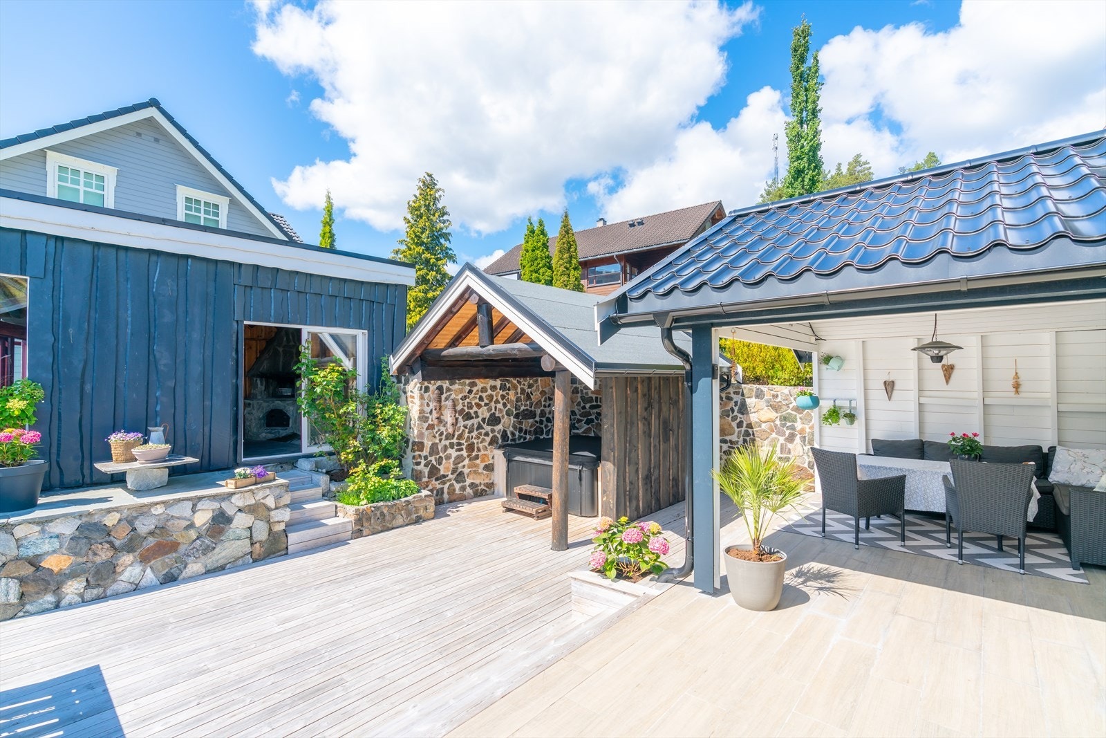 Det flotte uteområdet har overbygd uteplass, overbygd badestamp og utestove. Galleribilde