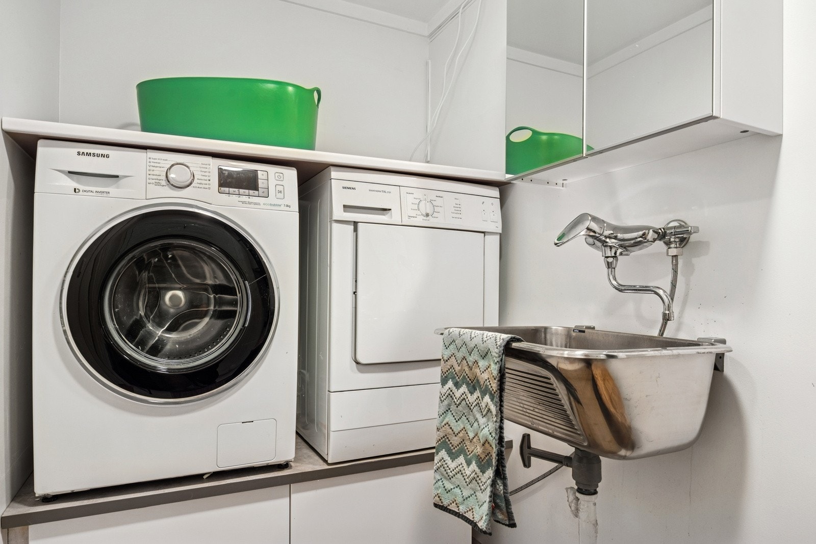 Lyst og praktisk vaskerom som i de senere år er oppgradert med skuffer, med plass for vaskemaskin og tørketrommel oppå. Galleribilde