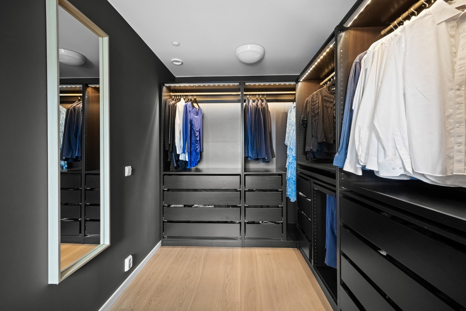 Walk-in-closet med skreddersydde løsninger, god oversikt og flott speil - perfekt for deg som verdsetter både stil og funksjon Galleribilde