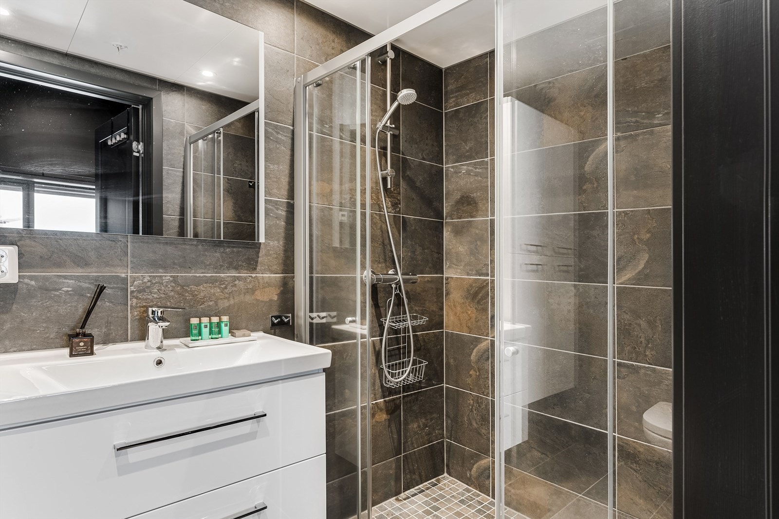 Nytt og moderne baderom med delikate fliser på gulv og vegger. Galleribilde