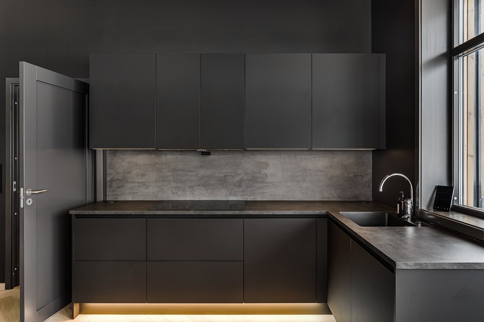 Kjøkkenet har et moderne utrykk med mørke og stilrene linjer. Galleribilde