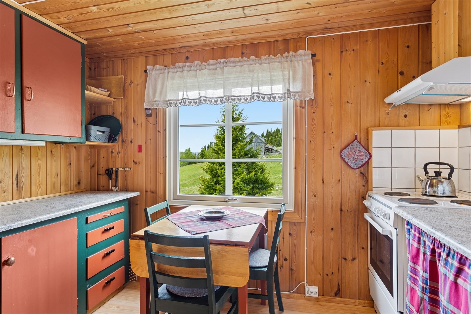 Innredning med over- og underskap samt plass til frittstående komfyr og kjøleskap. Galleribilde