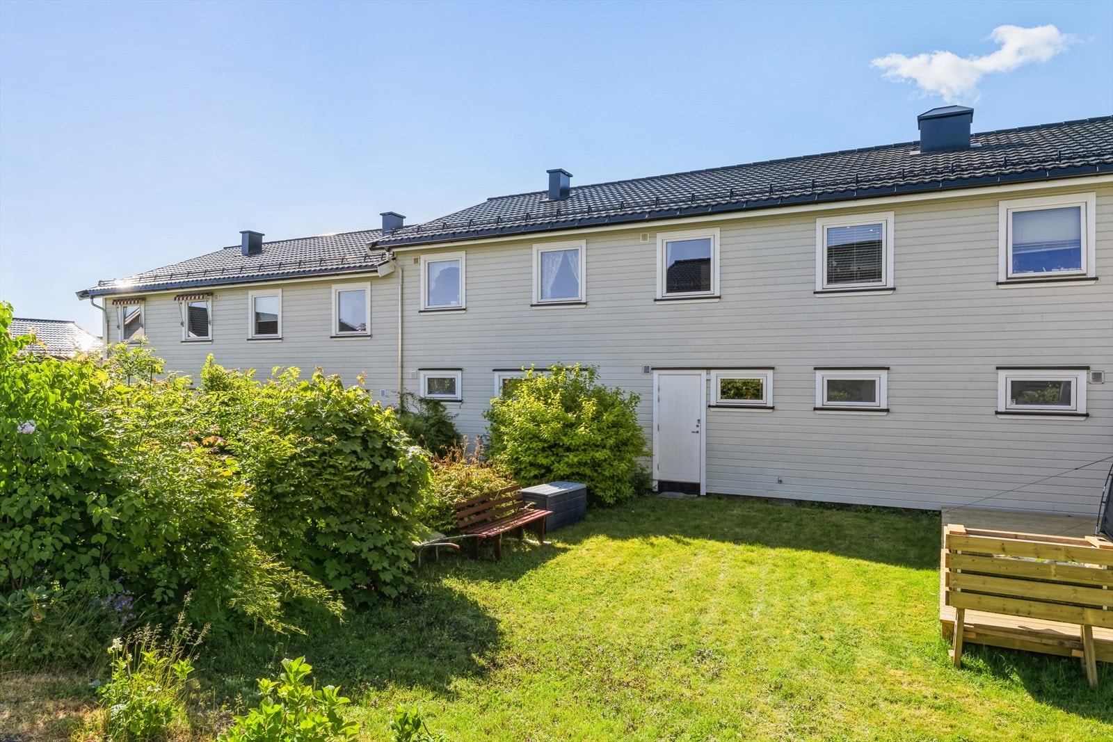 Koselig hage bak boligen med utgang fra bod Galleribilde