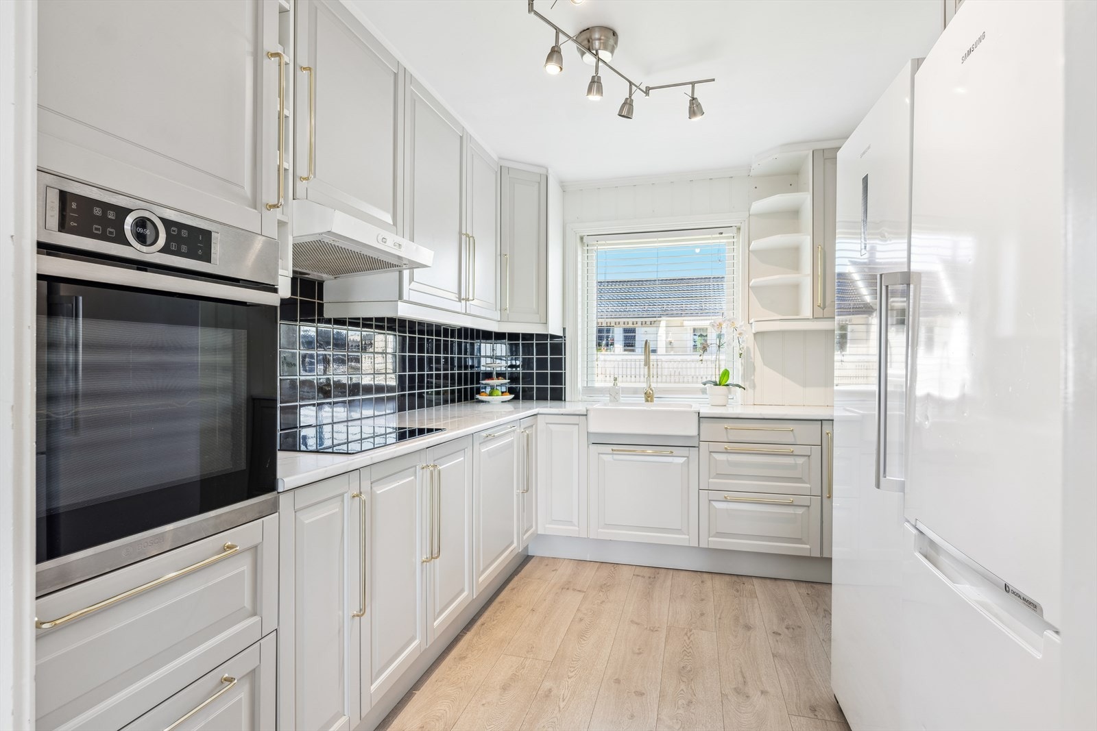 Kjøkkeninnredning fra 2009 hvor fronter og laminatbenk er byttet i 2018 med nedfelt porselensvask og blandebatteri. Galleribilde