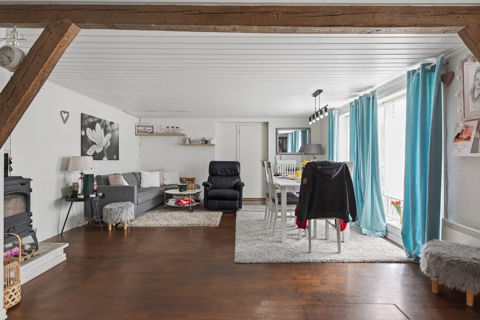 Stue gjennomført i lyse farger. Peisovn, og lukeadkomst til kjeller i gulvet. Galleribilde