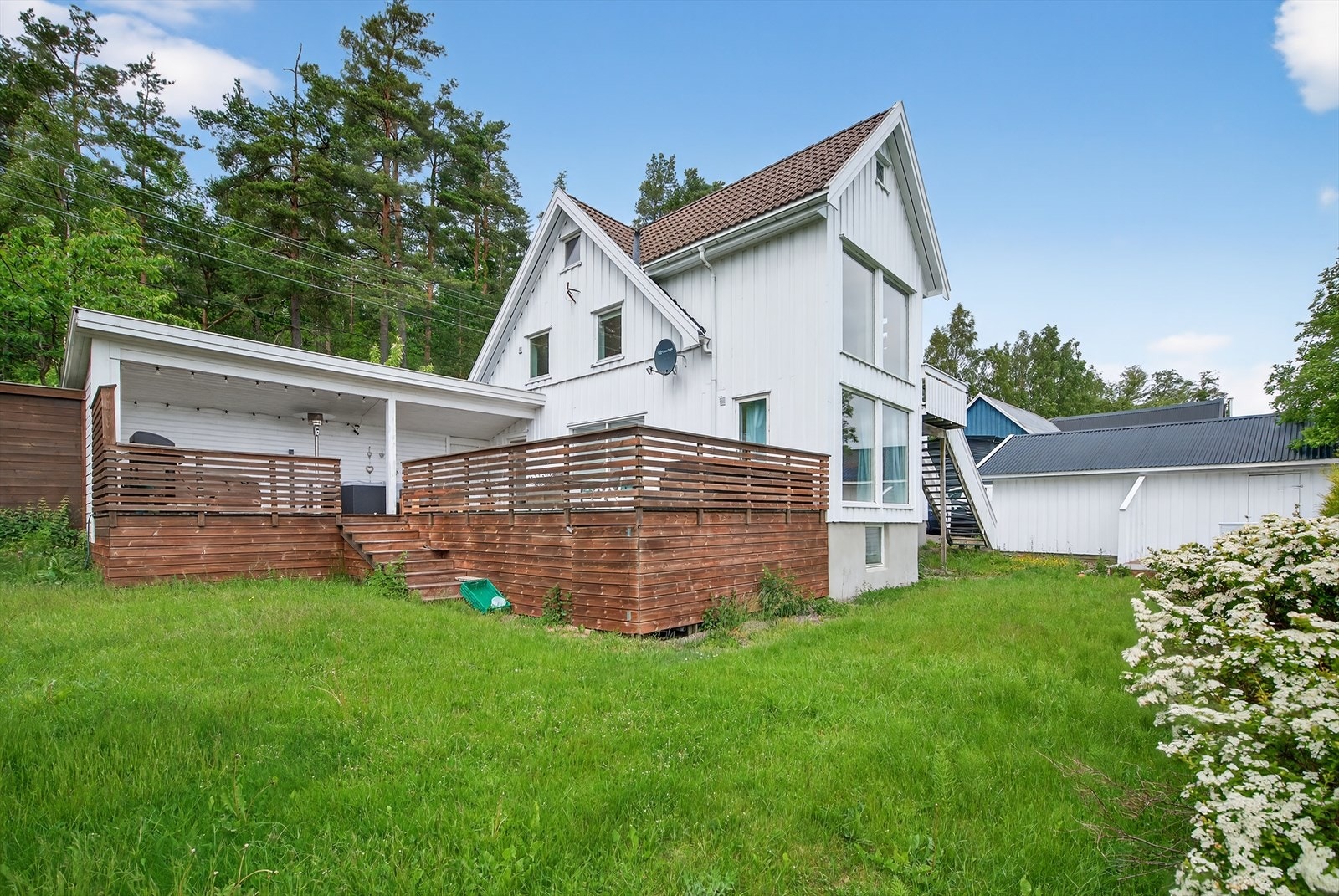 Boligen har en romslig opparbeidet tomt med gressplen og prydbusker. Galleribilde