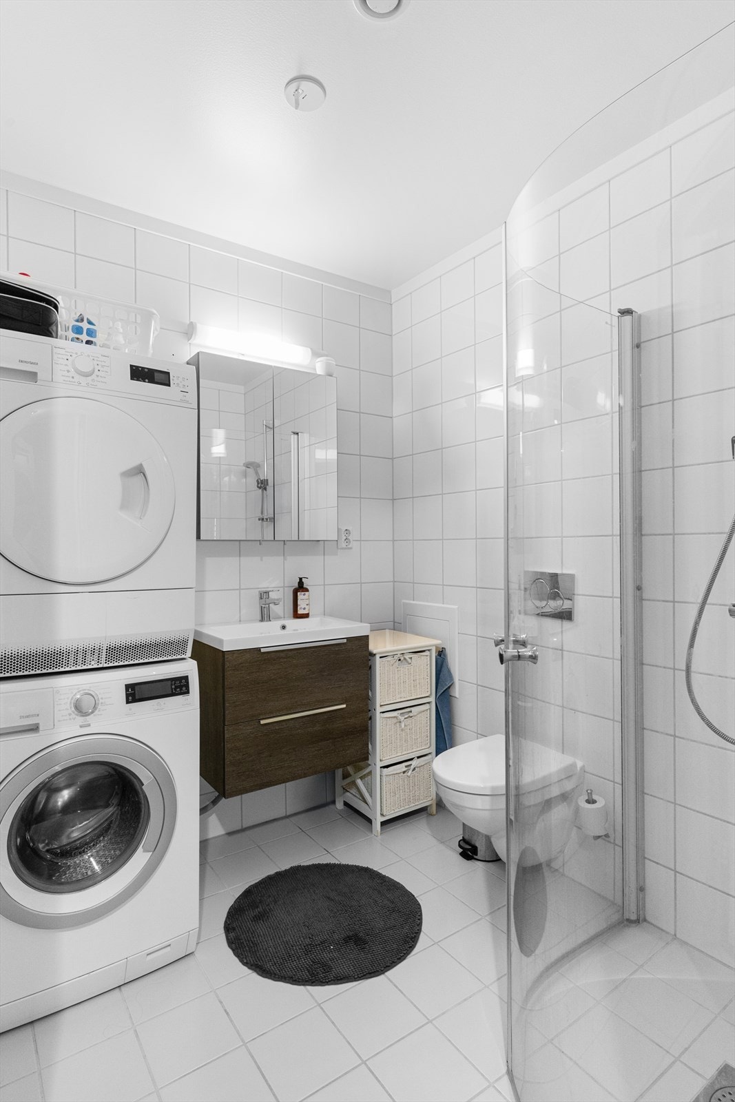 Badet har ny baderomsinnredning med nedfelt servant, veggmontert toalett, dusjvegger/hjørne og opplegg for vaskemaskin og tørketrommel. Galleribilde