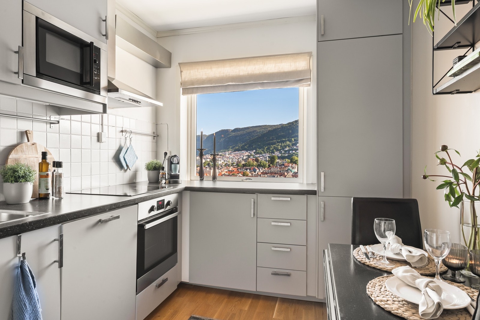 Lys og innbydende kjøkkenløsning med 3-stavs laminat på gulvet og god skapplass. Galleribilde