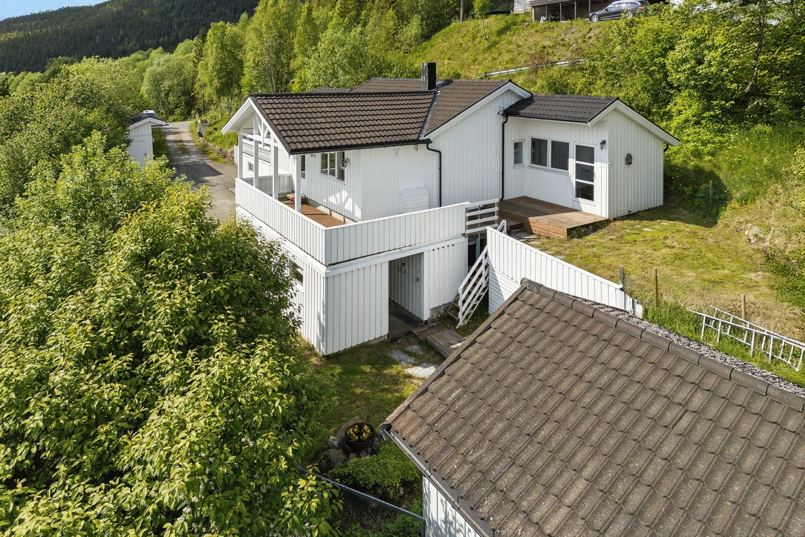 Opparbeidet tomt med plen og prydbusker. Gruset innkjørsel og gårdsplass. Galleribilde