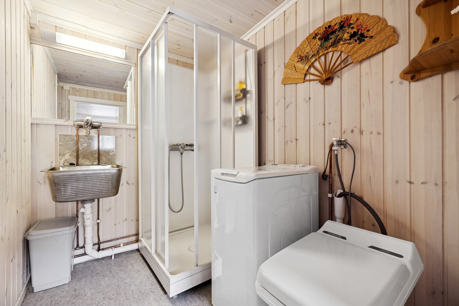 Baderom fra 2018 innredet med vaskekum med overspeil, dusjkabinett og forbrenningstoalett. Galleribilde