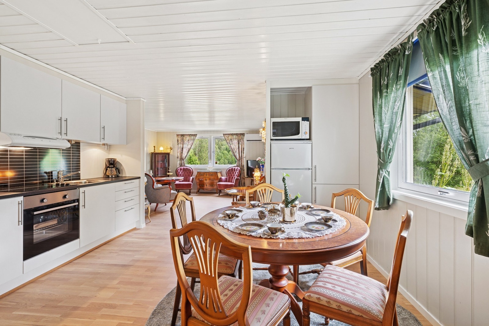 Med åpen løsning mot stuen blir kjøkkenet en sosial og trivelig sone. Kjøkkenet er av klassisk karakter, i lys utførelse. Galleribilde