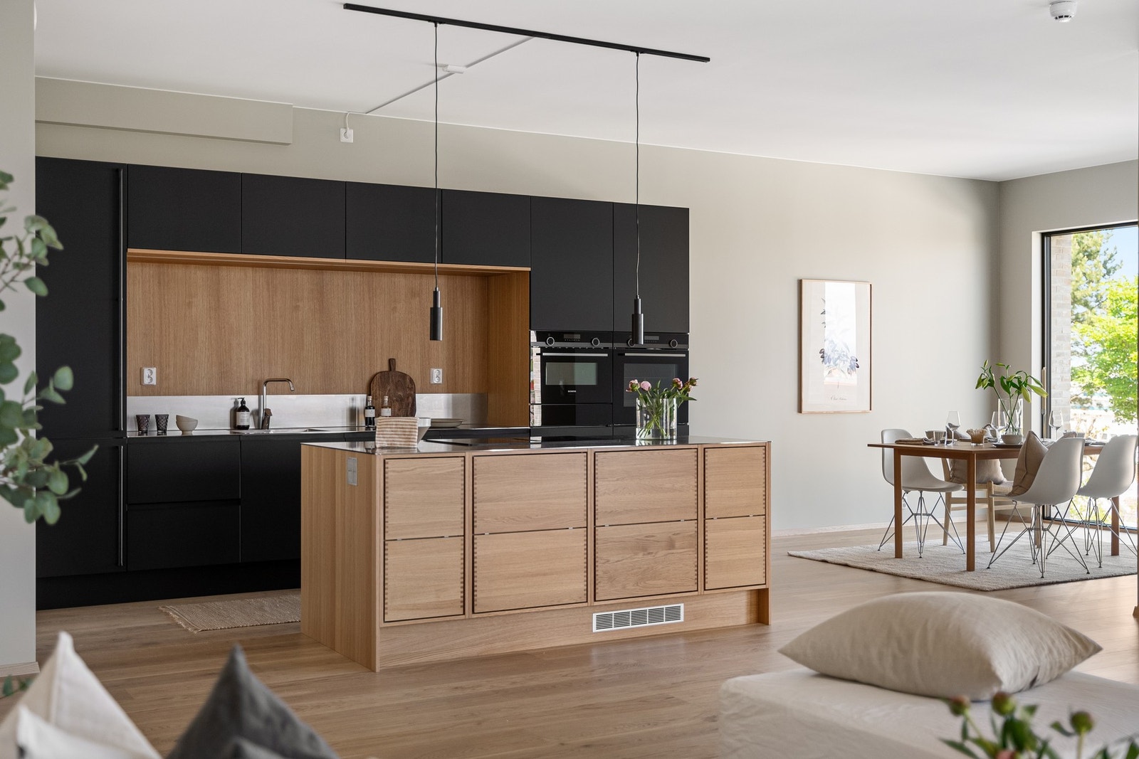 Lekkert Svane kjøkken som kombinerer sort og eik med benkeplater i stål. Galleribilde