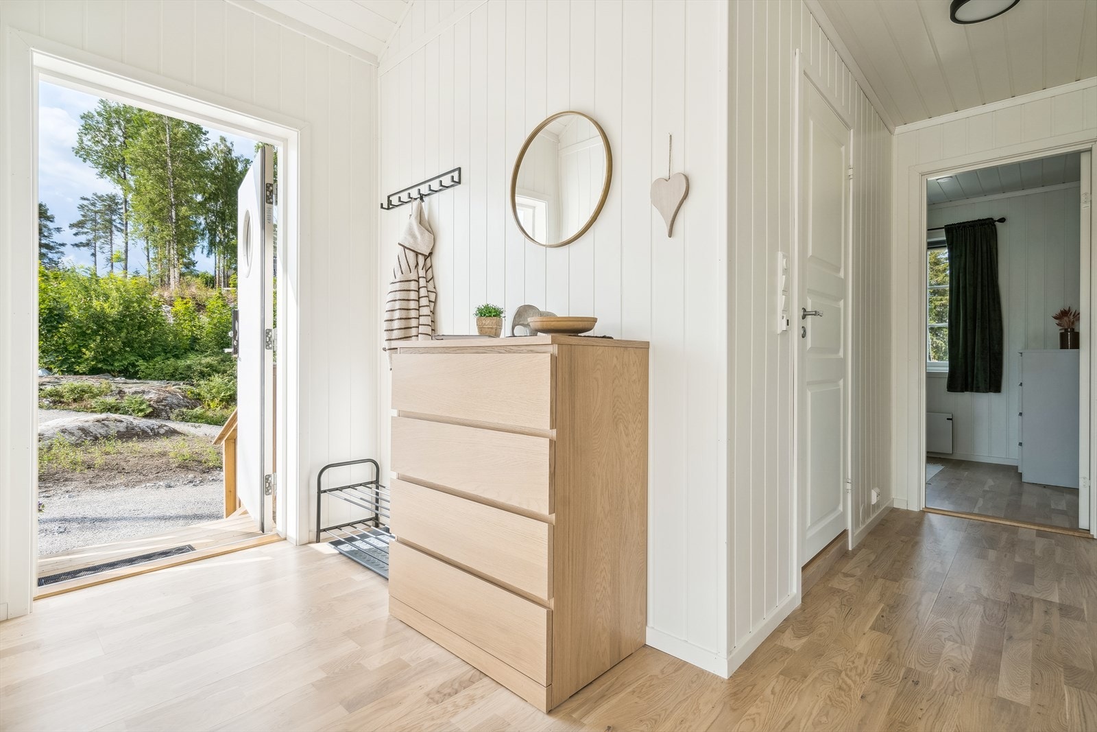 Lyst og innbydende inngangsparti med plass for yttertøy og sko. Galleribilde