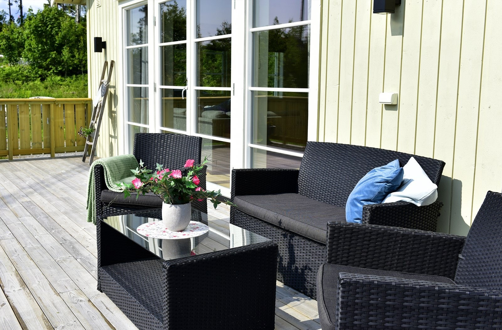 Stor terrasse med plass for flere sittegrupper, grill og solsenger. Galleribilde