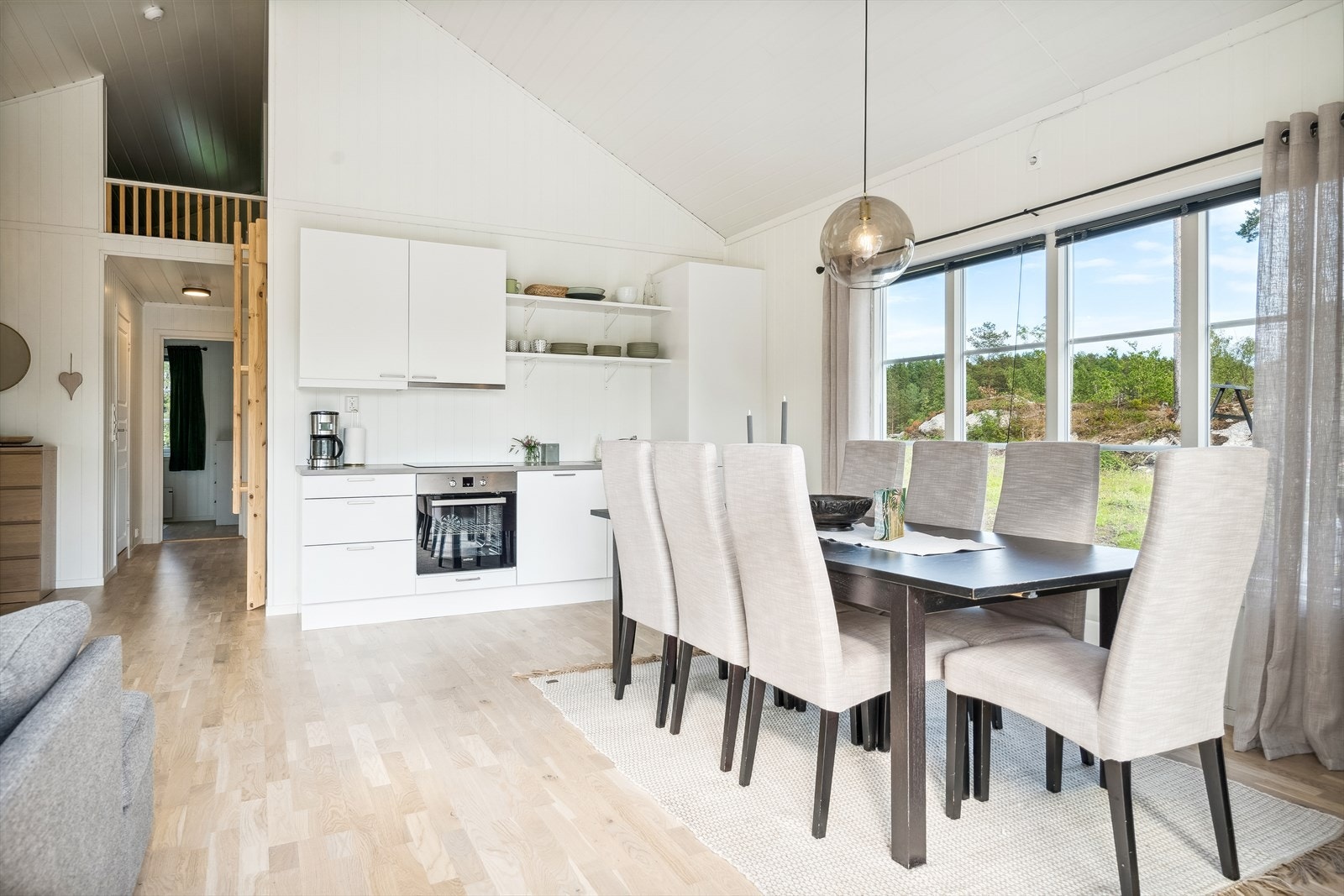Kjøkkeninnredning med hvite, glatte fronter og grå benkeplate av laminat med nedfelt kum og blandebatteri. Galleribilde