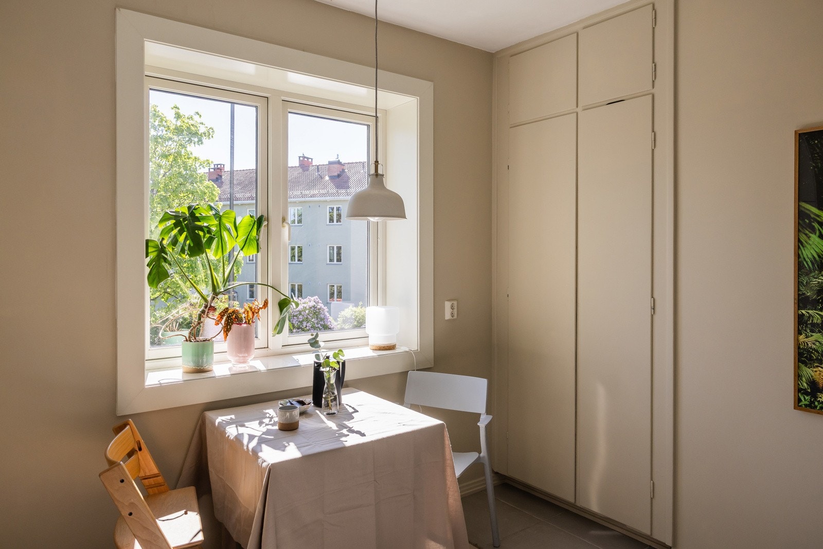 Sitteplass ved vindu med utsyn mot frodige fellesareal. Galleribilde