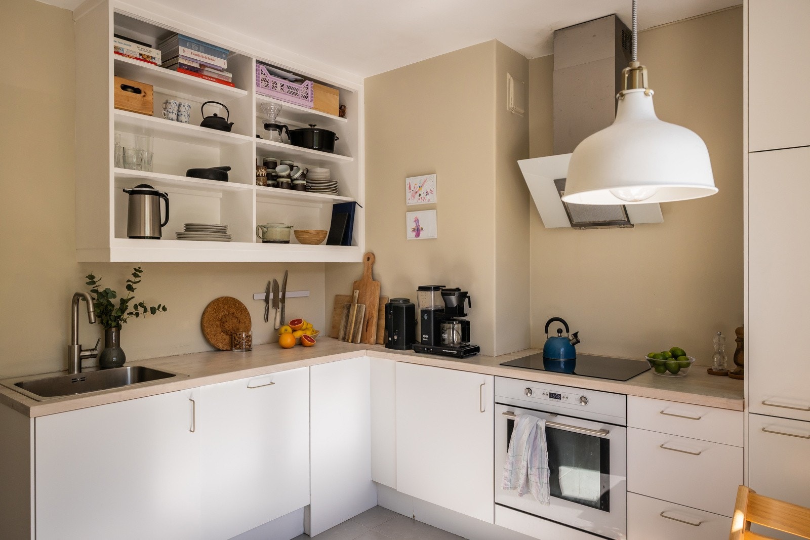 Innredning fra IKEA med hvite, glatte fronter, oppvaskmaskin fra 2024, stekeovn/koketopp, kjøl/frys og automatisk vannstopper. Galleribilde