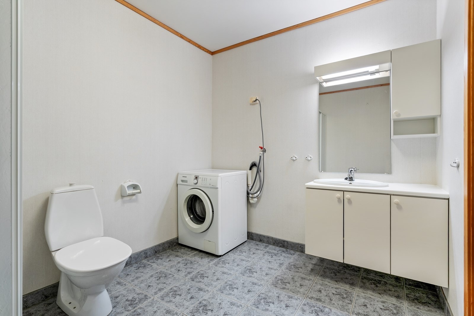 Romslig baderom med opplegg for vaskemaskin. Galleribilde