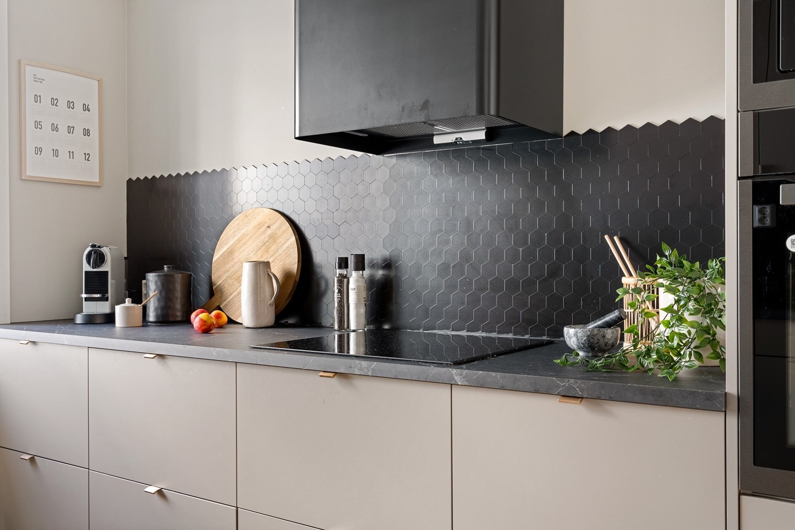 Kjøkkenet er innredet med slette beige fronter, laminat benkeplate og praktisk backsplash for enkel rengjøring. Galleribilde