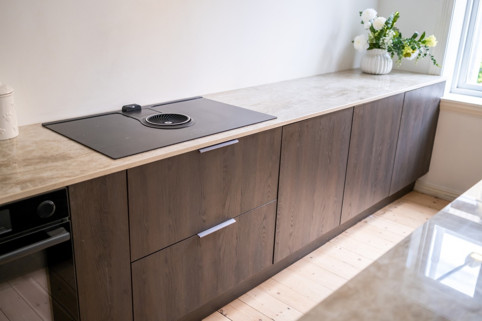 Kjøkkenet har eksklusive tilvalg som koketopp med integrert ventilator og Quooker armatur som leverer både boblevann og kokende vann rett fra springen. Galleribilde