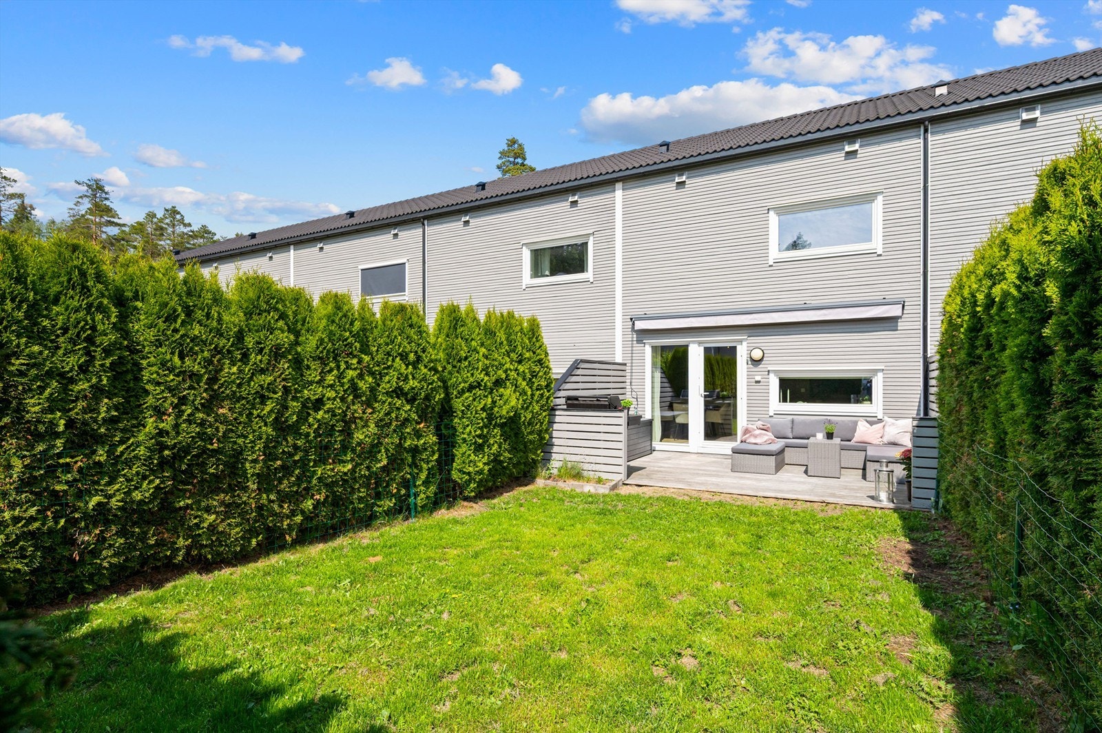 Terrassen glir sømløst over i en plen som er omkranset og god skjermet med tujahekk. Terrassen og hagen vender mot sydvest og har svært gode solforhold. Galleribilde