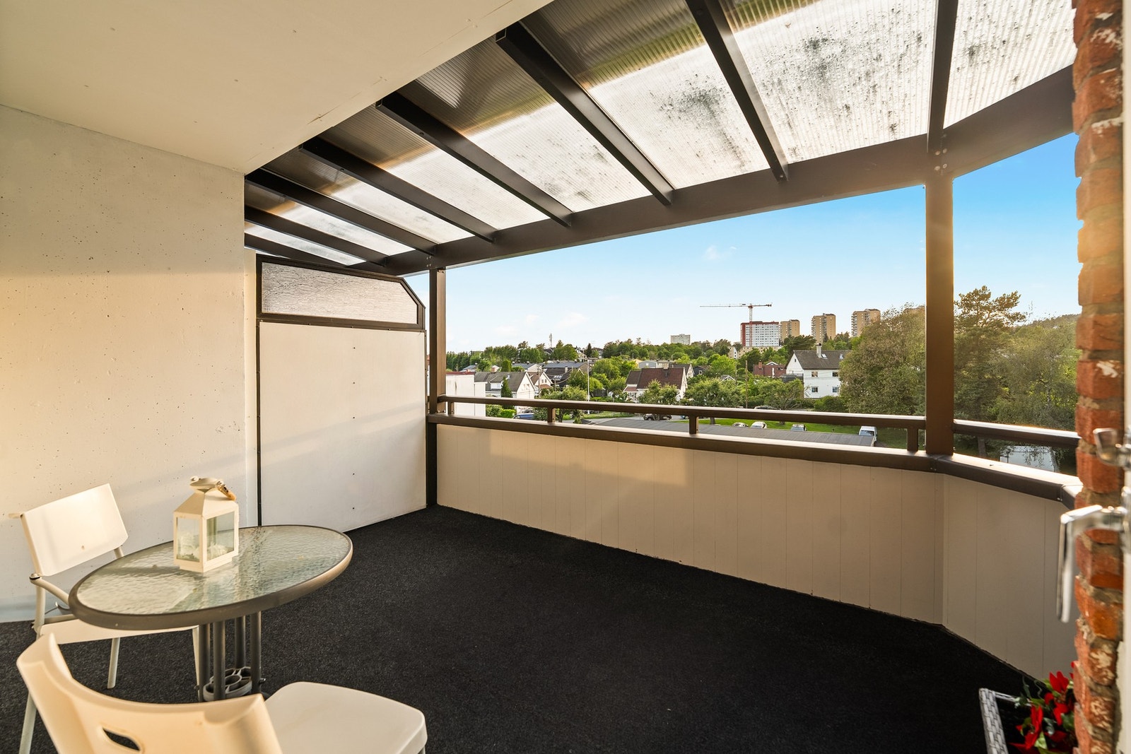 Leiligheten har en romslig og overbygget balkong på ca. 9 m² med hyggelig utsyn mot grøntarealer og nabolag. Galleribilde