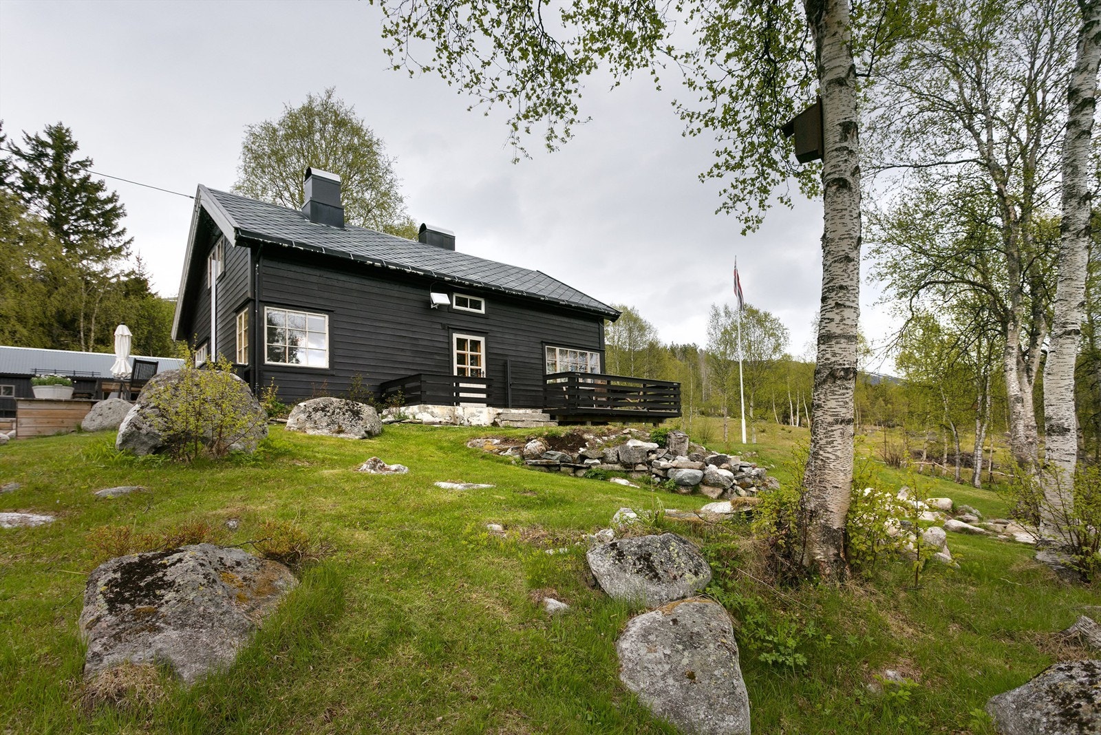 Fasade fritidsbolig og pent opparbeidet uteområde Galleribilde