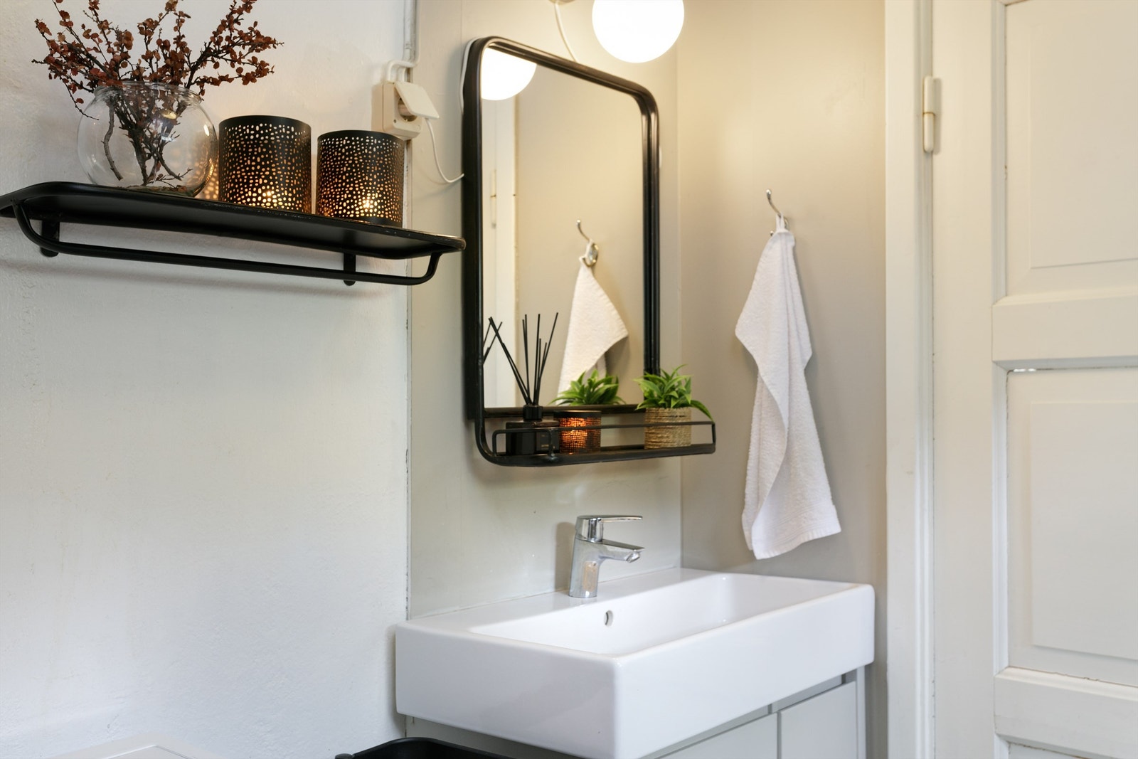 Detaljefoto fra badet. Innredning med ovenpåliggende servant med ett-greps armatur. Speil og stikkontakt over servant. Galleribilde