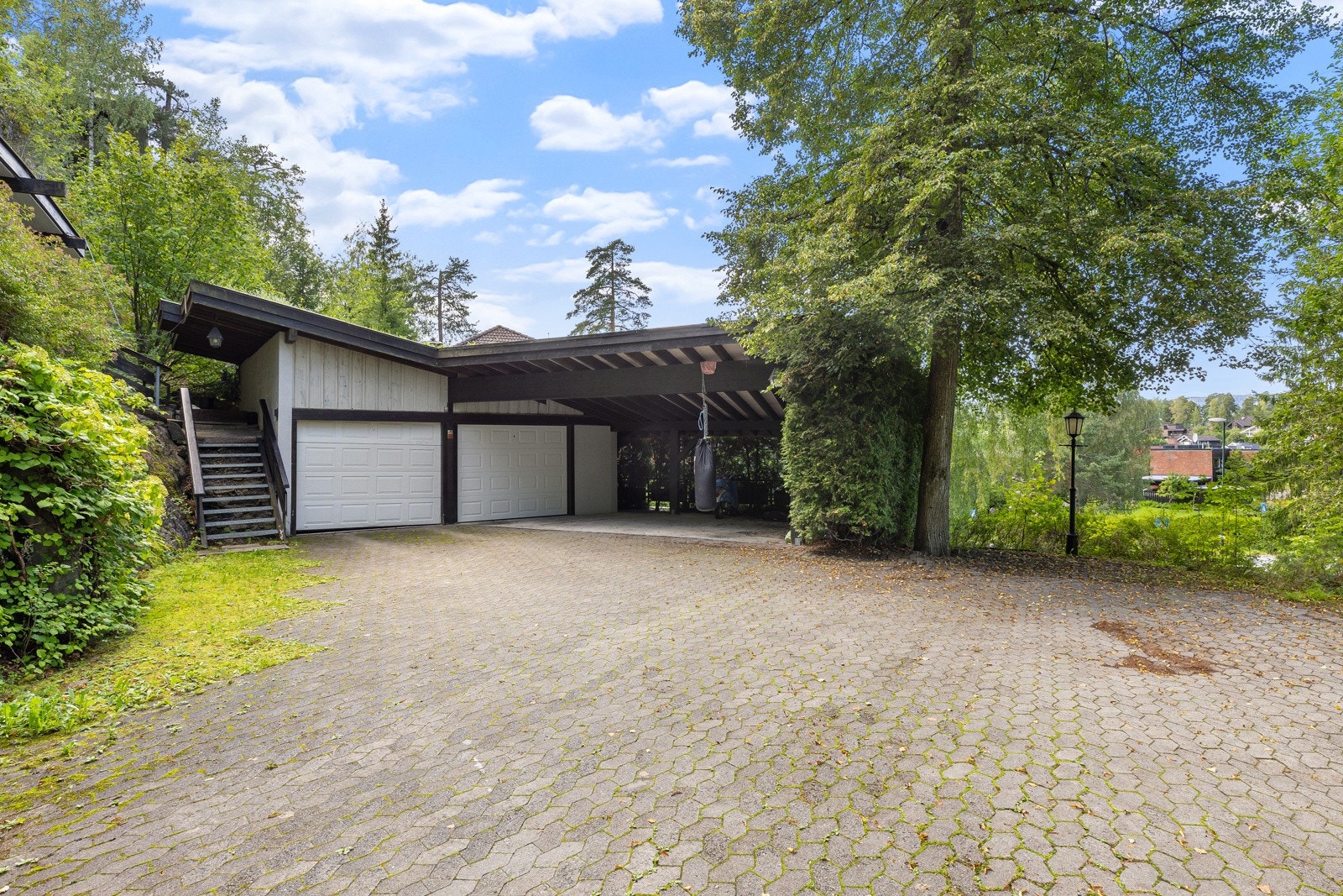Gode parkeringsmuligheter i garasje, carport og på egen gårdsplassen på nedsiden av eiendommen Galleribilde