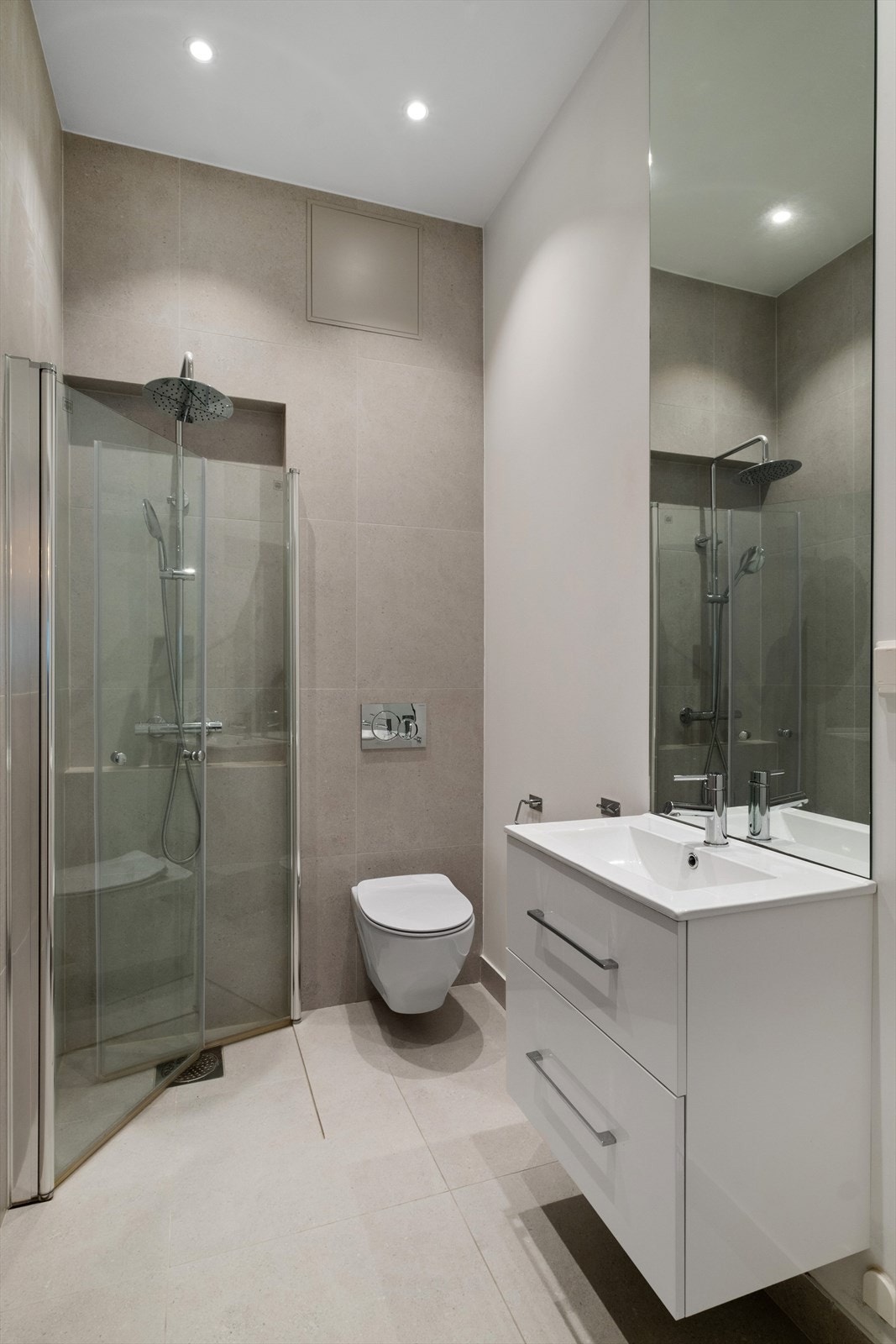 Baderom 2 har et moderne og stilrent design med store, nøytrale fliser som gir et elegant og harmonisk uttrykk. Galleribilde