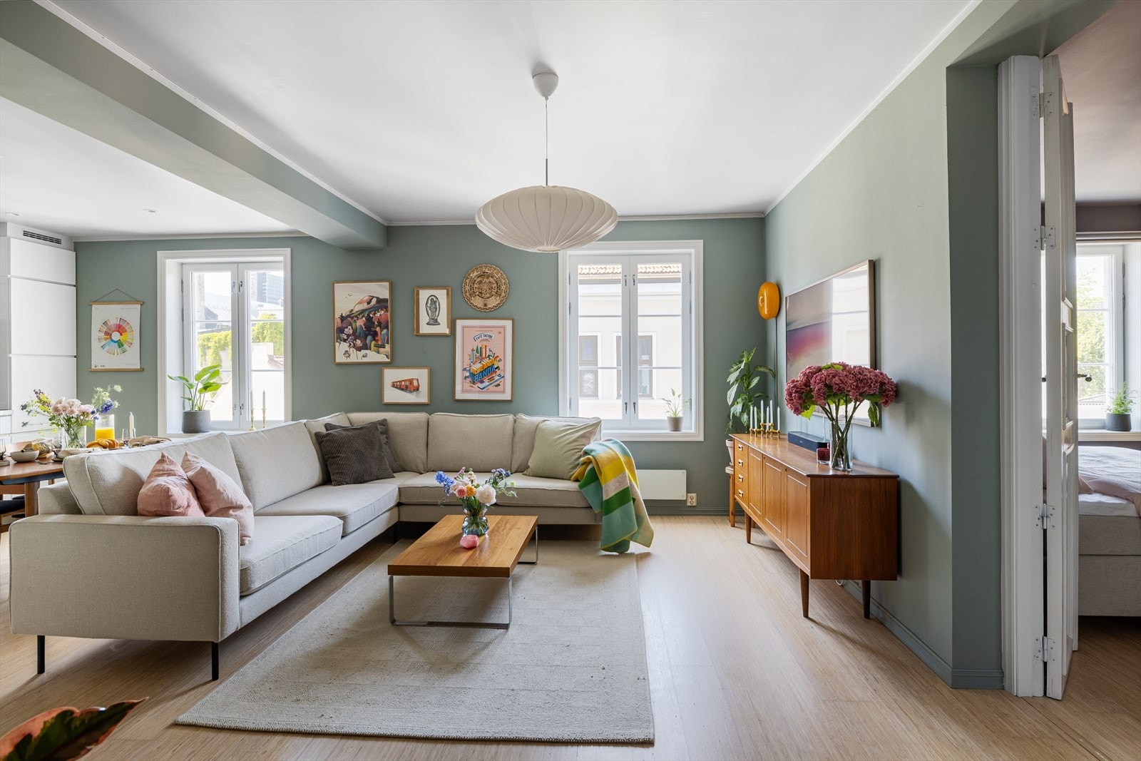 Romslig stue imponerer med store vindusflater som slipper inn rikelig med naturlig lys og skaper en åpen og luftig atmosfære Galleribilde