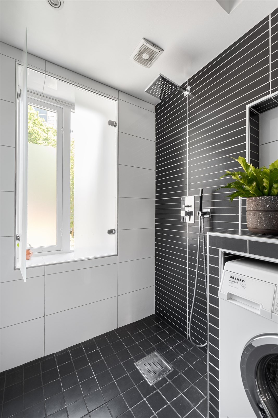 Baderomsinnredningen består av servant med underskap, speil med belysning, veggehengt toalett og en romslig dusjsone Galleribilde