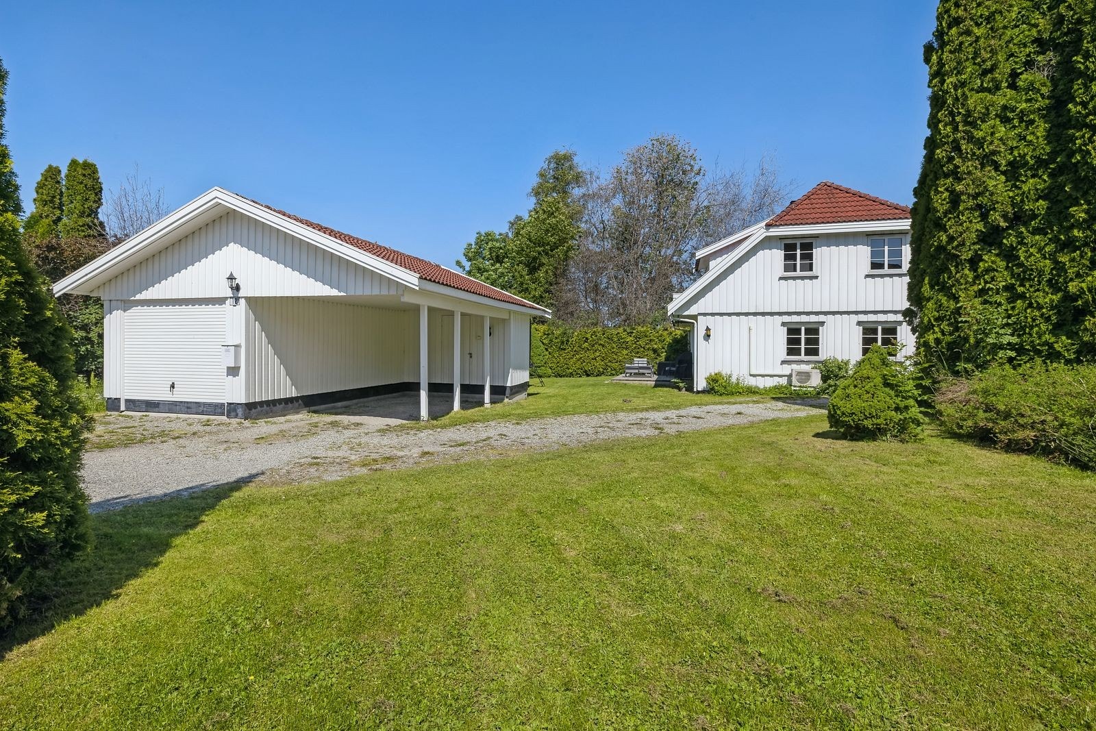Fasade fra oppkjørselen med garasje og carport Galleribilde