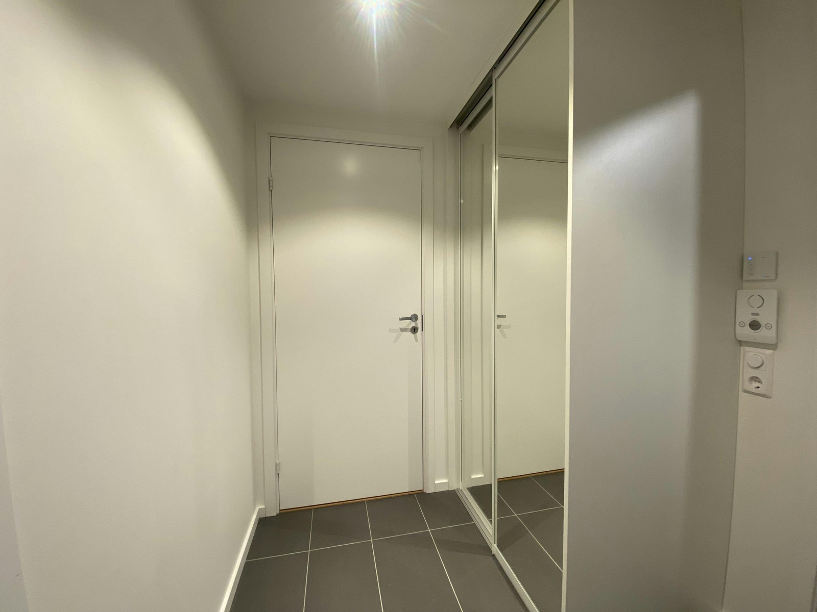 Lys flislagt entré med skyvedørs garderobe Galleribilde