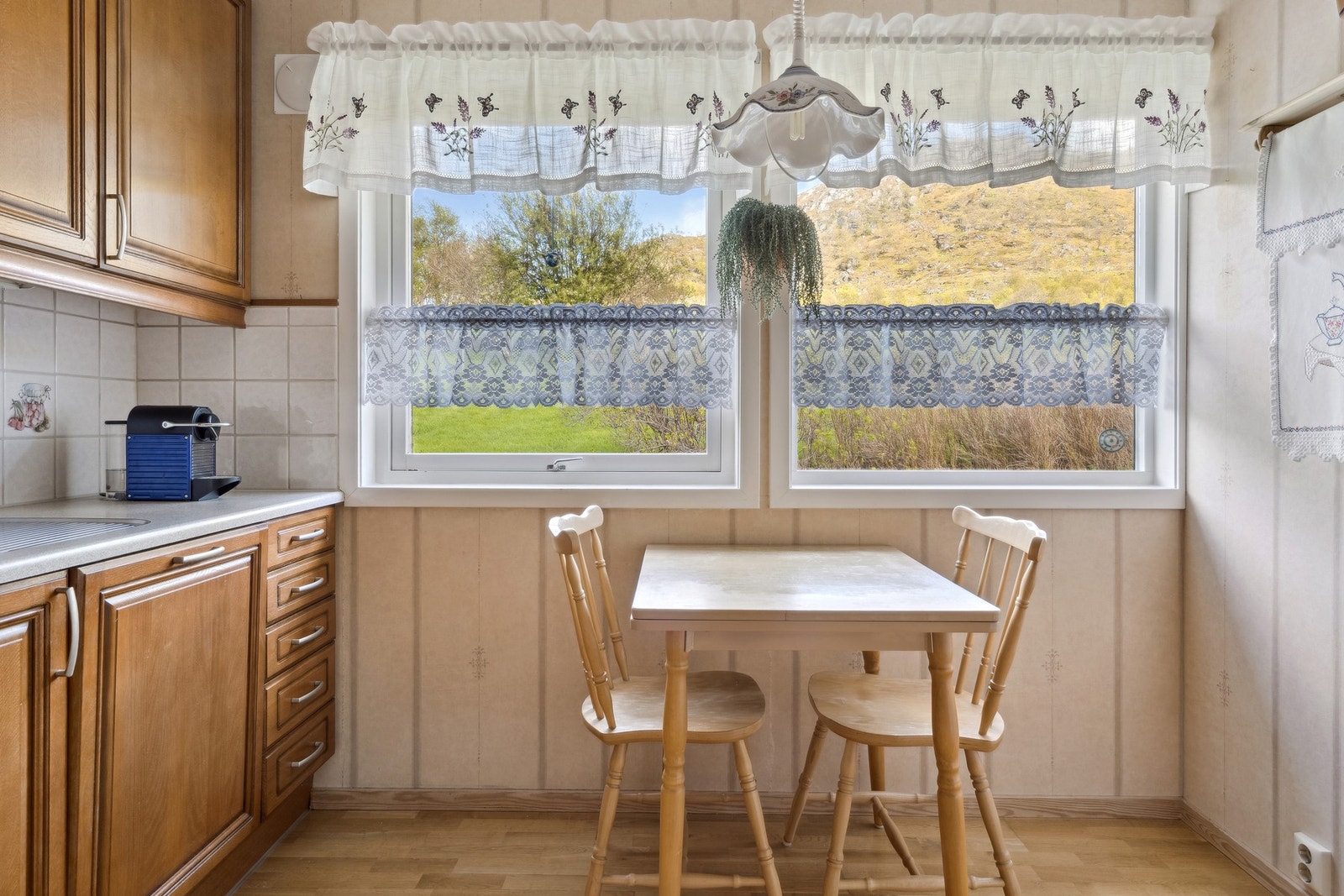 Plass til en mindre spisegruppe på kjøkkenet med utsikt til baksiden av eiendommen. Galleribilde