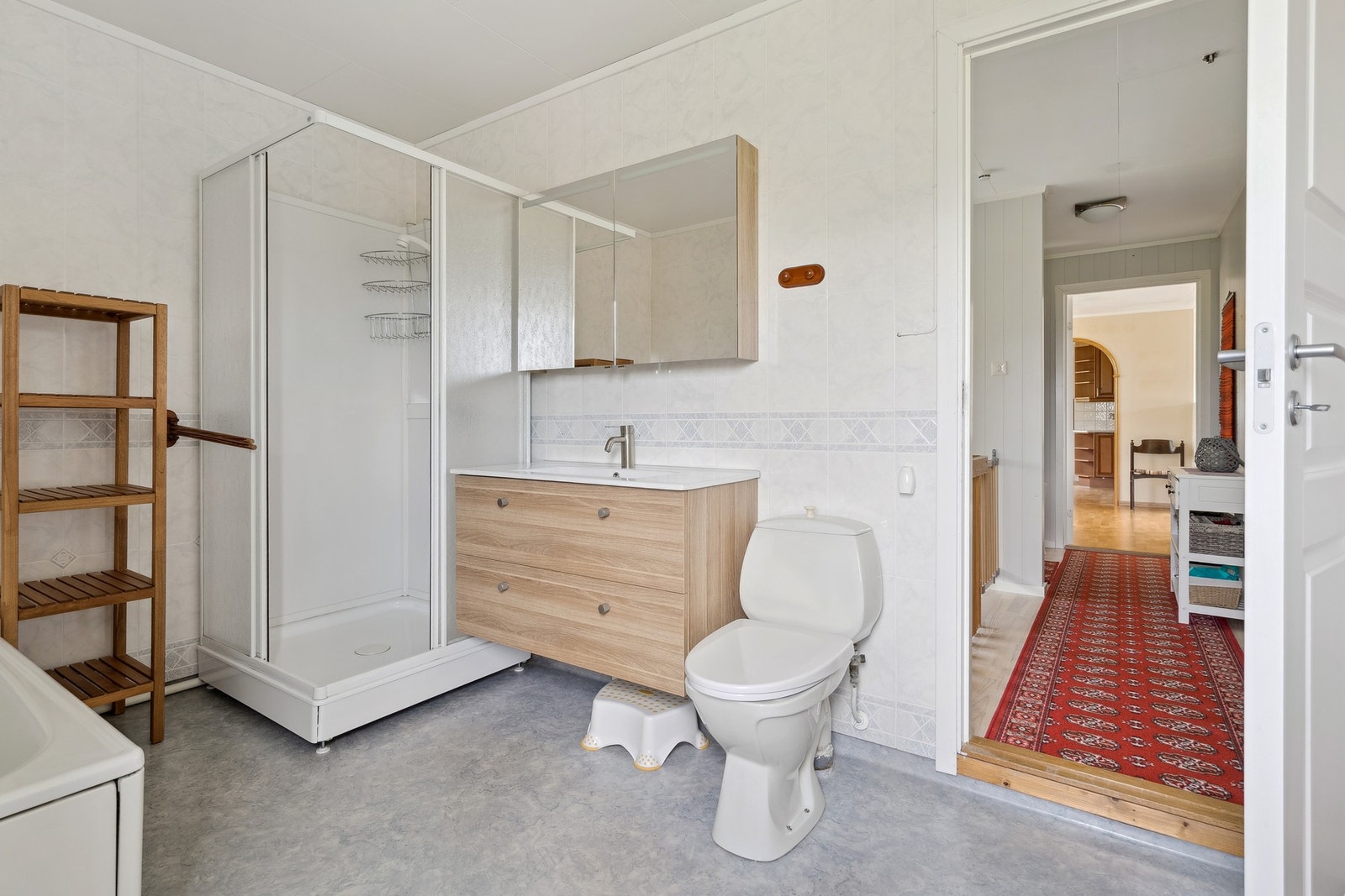 Bad fra 90-tallet med nyere innredning og speil med lagringsplass. Galleribilde