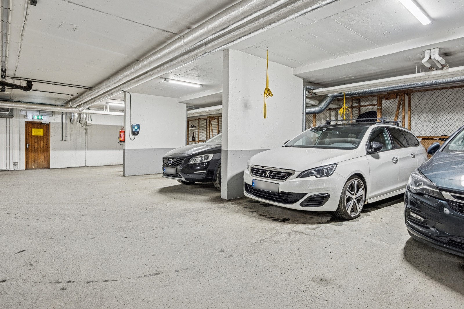 Rett ved har man p-plass i oppvarmet garasjekjeller. Her har man en liten nettingbod i bakkant for oppbevaring av diverse. Galleribilde