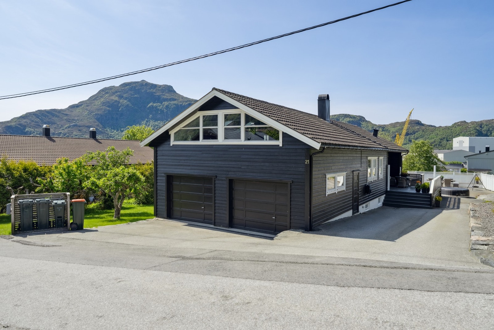 Pent oppabeide uteområder med asfaltert innkjørsel og grøntområde på boligens sørside. Galleribilde